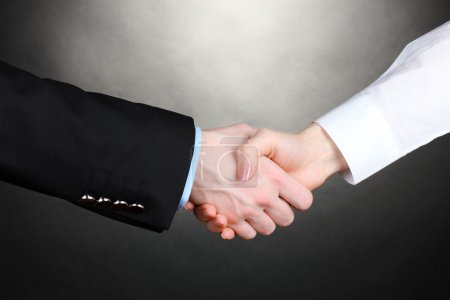 Poignée de main d'affaires sur fond gris 