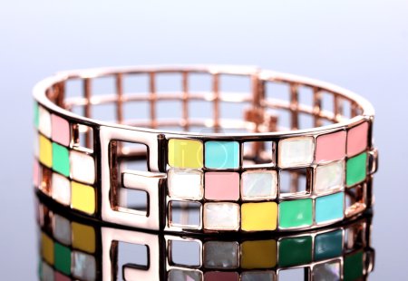 Beau bracelet doré sur fond gris 