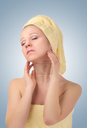 Belle jeune femme en serviette jaune sent le plaisir avec près 