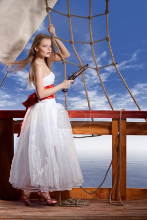 Belle fille en robe blanche sur le pont du voilier 