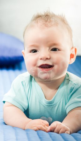 Souriant bébé garçon au lit 