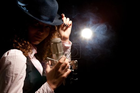 Belle chanteuse en chapeau avec microphone 