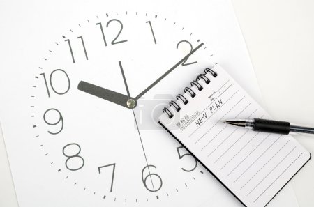 Horloge visage et bloc-notes avec stylo 