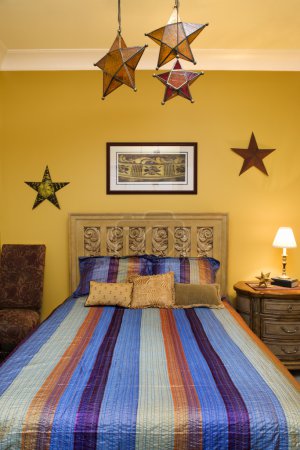 Intérieur de la chambre avec couvre-lit rayé et étoiles décoratives 