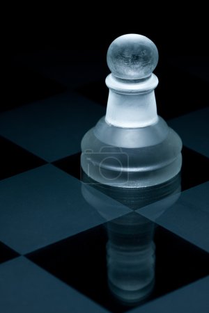 Macro shot de pion d'échecs en verre sur fond noir 