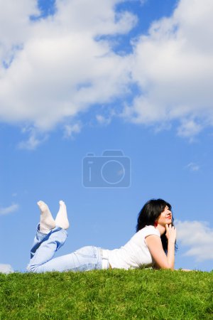 Jolie femme repose sur l'herbe verte 