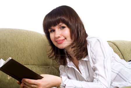 Fille lisant un livre sur le canapé isolé 